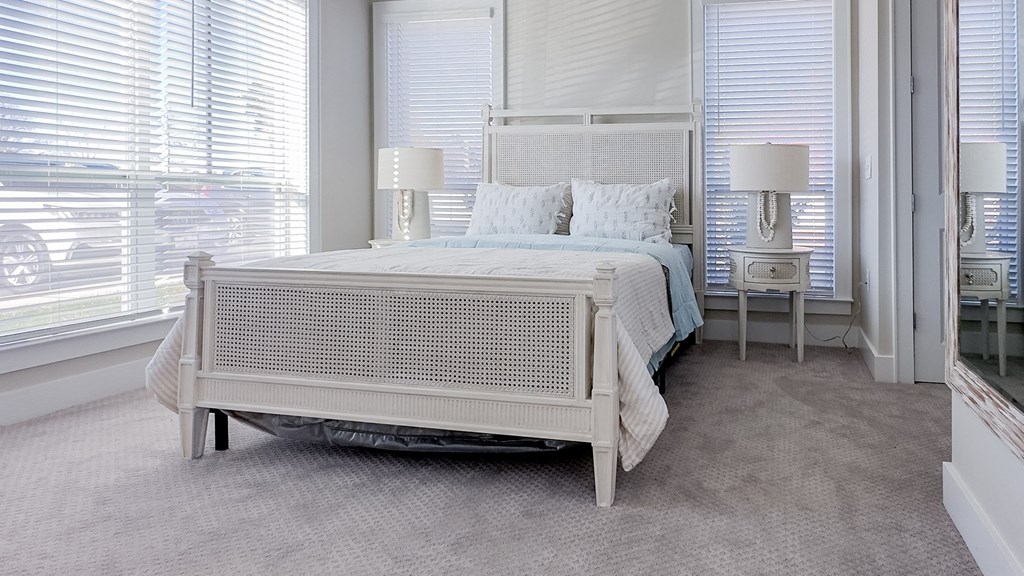 a bedroom with a bed and two windows