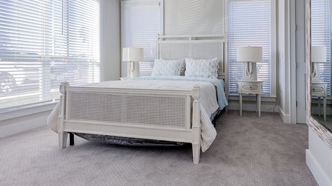a bedroom with a bed and two windows