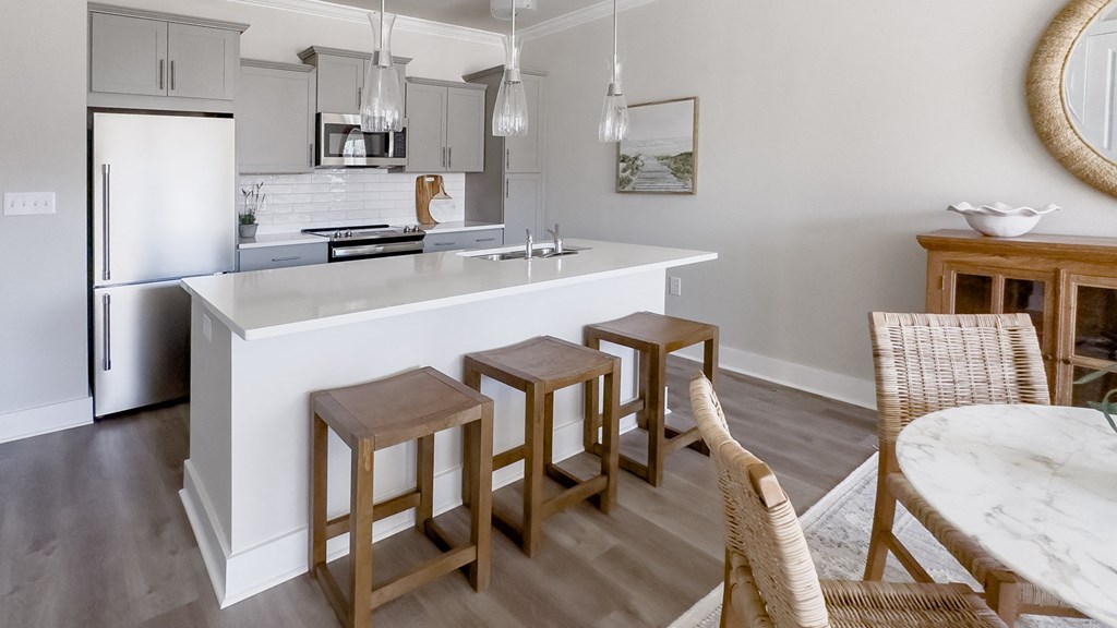 a kitchen with a white counter top and three stools