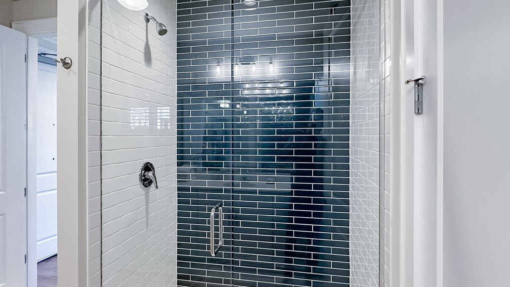 a blue and white tiled shower in a bathroom