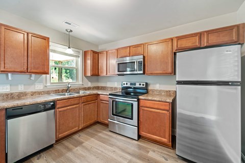 A kitchen with wooden cabinets and stainless steel appliances.