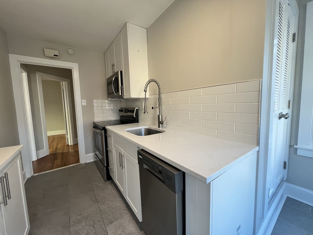 an empty kitchen with a sink and a counter top