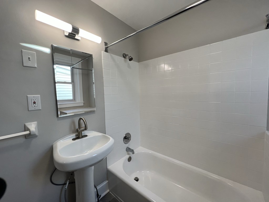 a bathroom with a sink and a tub and a mirror