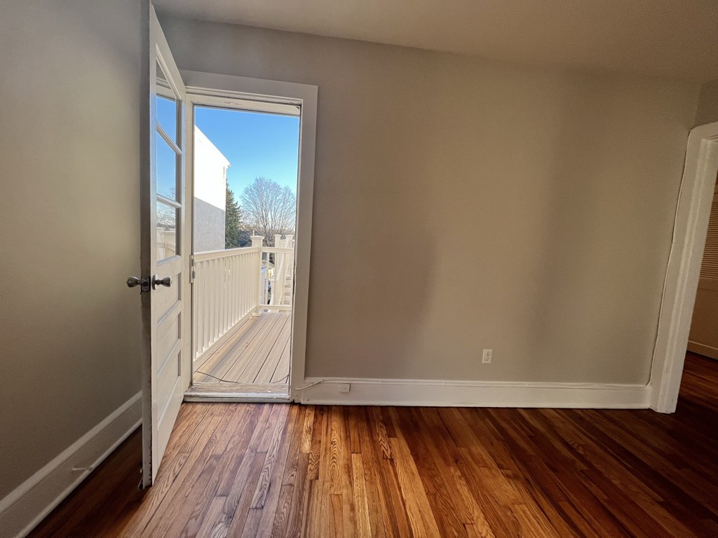 an empty room with a door open to a balcony