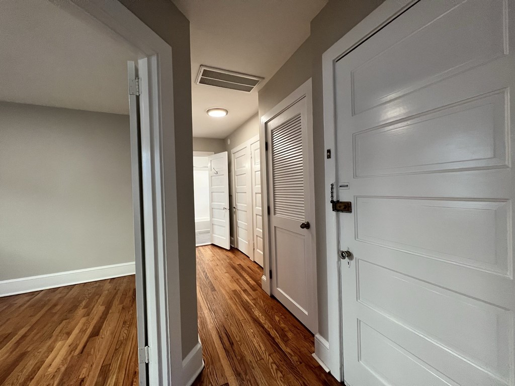 a hallway with a white door leading to a closet