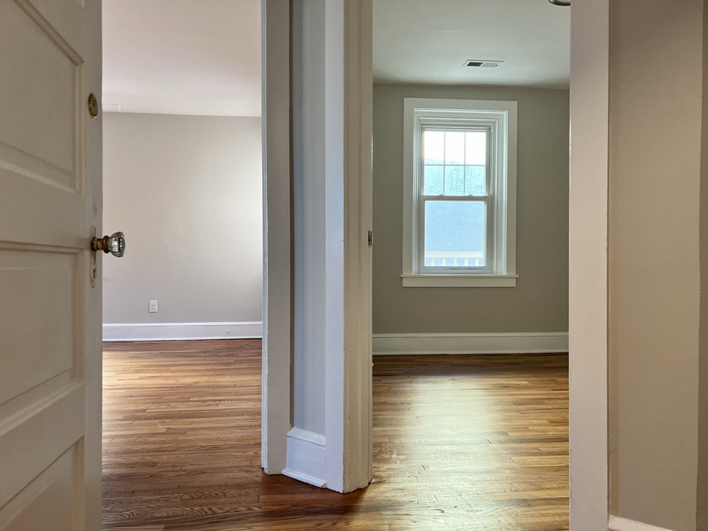 an empty room with wood floors and a window