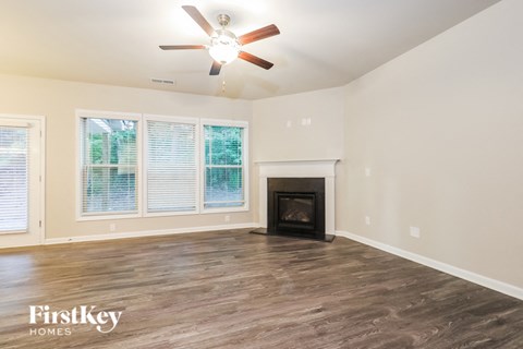 a living room with a fireplace and a ceiling fan