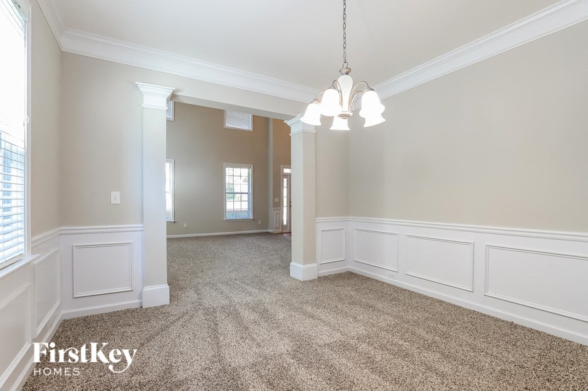 an empty living room with white walls and carpet