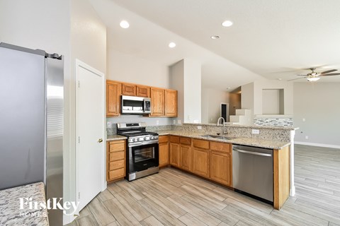 A kitchen with wooden cabinets and a marble countertop.