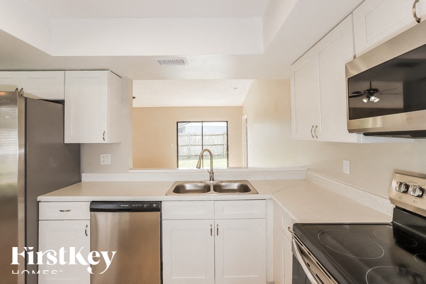 a white kitchen with stainless steel appliances and white cabinets