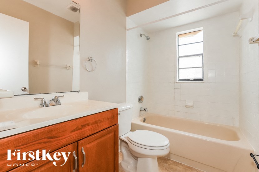 a bathroom with a toilet and a tub and a sink