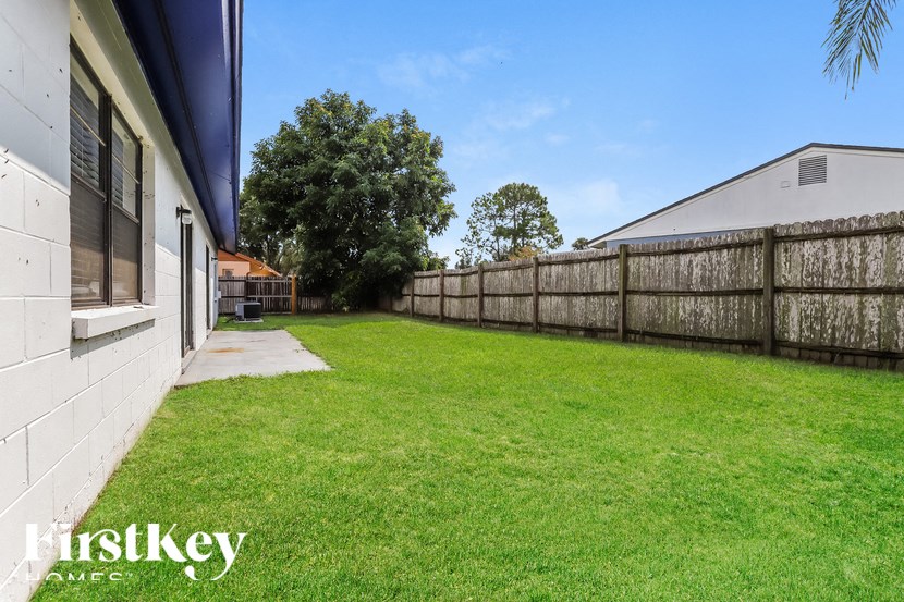 the backyard of a house with a fence and grass