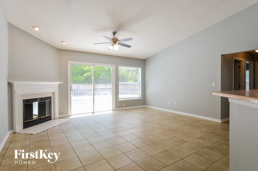 A spacious living room with a fireplace and sliding glass doors.