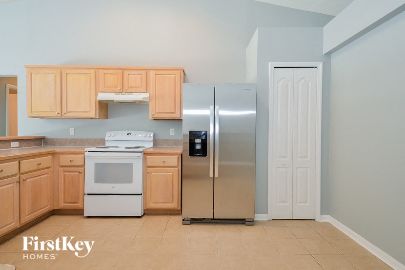 A kitchen with wooden cabinets and a stainless steel refrigerator.