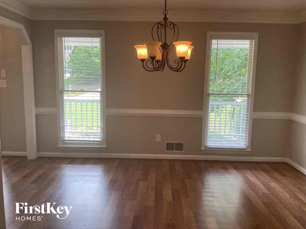 A room with wooden floors and a chandelier hanging from the ceiling.