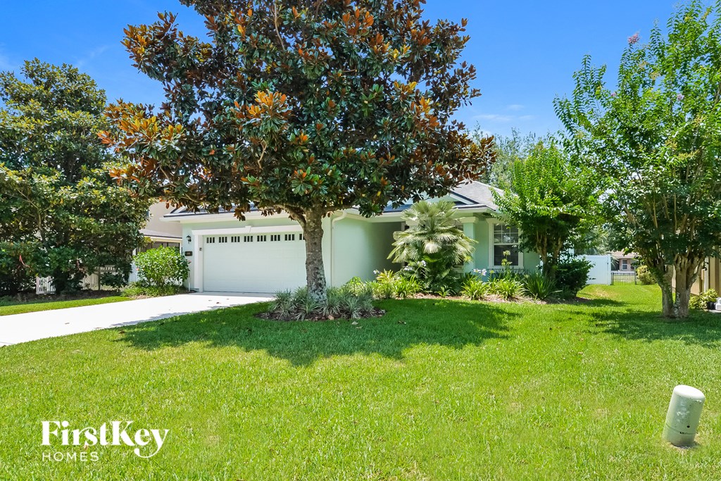a home with a lawn and a tree in front of it