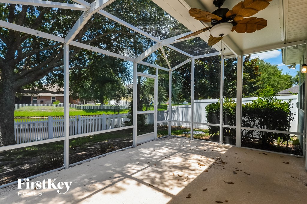 a conservatory with a ceiling fan and glass doors