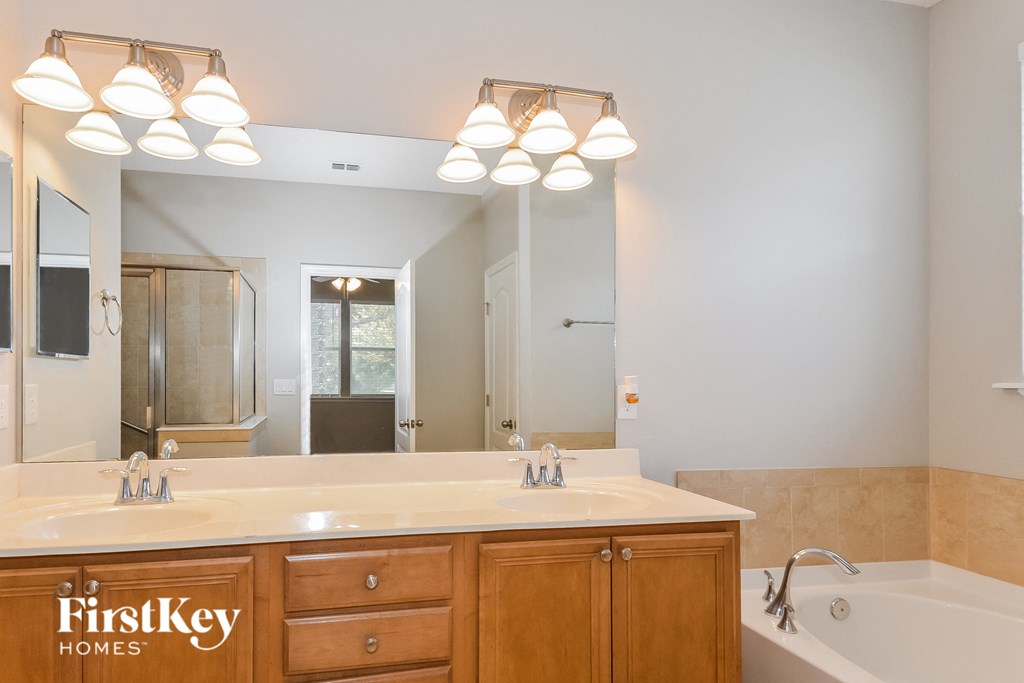a bathroom with a large mirror and a sink and a tub