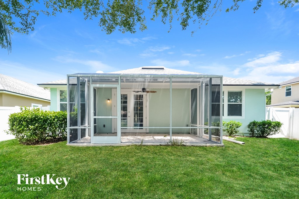 a screened in porch with glass doors in front of a house