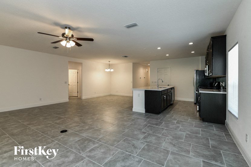 an empty kitchen and living room with a ceiling fan