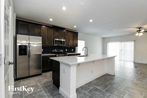 a large kitchen with stainless steel appliances and a white counter top