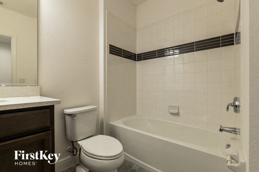 a bathroom with a toilet and a tub and a sink