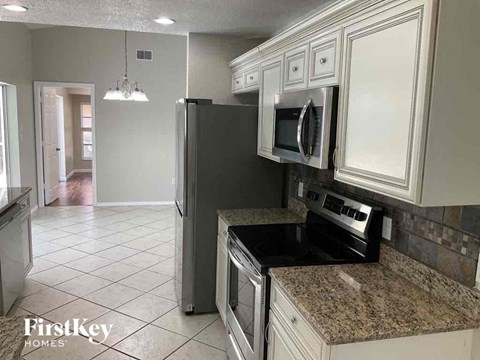 a kitchen with white cabinets and a stove and a refrigerator