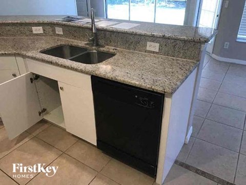 a kitchen with a sink and a black dishwasher
