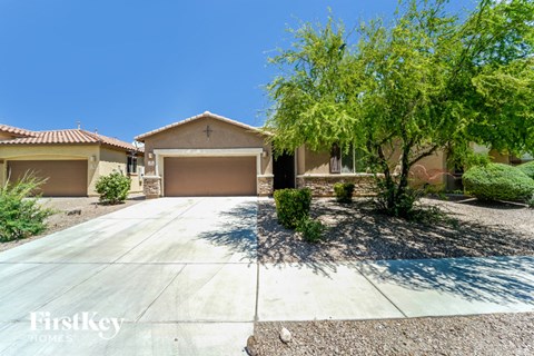 a house with a driveway and a tree in front of it
