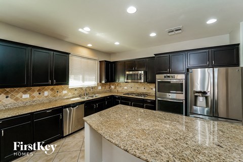 a kitchen with granite counter tops and stainless steel appliances