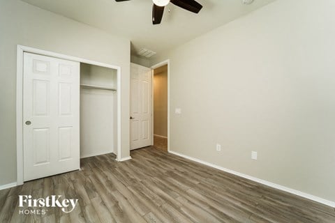 an empty bedroom with a closet and a ceiling fan