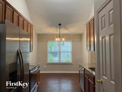 A kitchen with wooden cabinets and a stainless steel refrigerator.