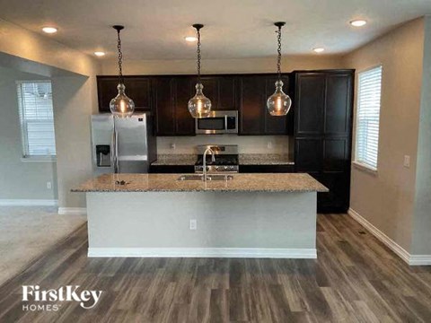 A kitchen with a granite countertop and a FirstKey HOMES logo.