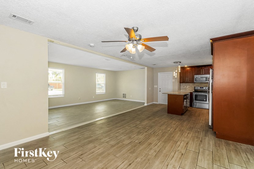a kitchen and living room with wood floors and a ceiling fan