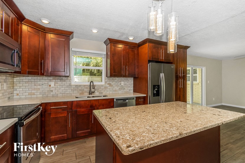 a kitchen with granite counter tops and wooden cabinets
