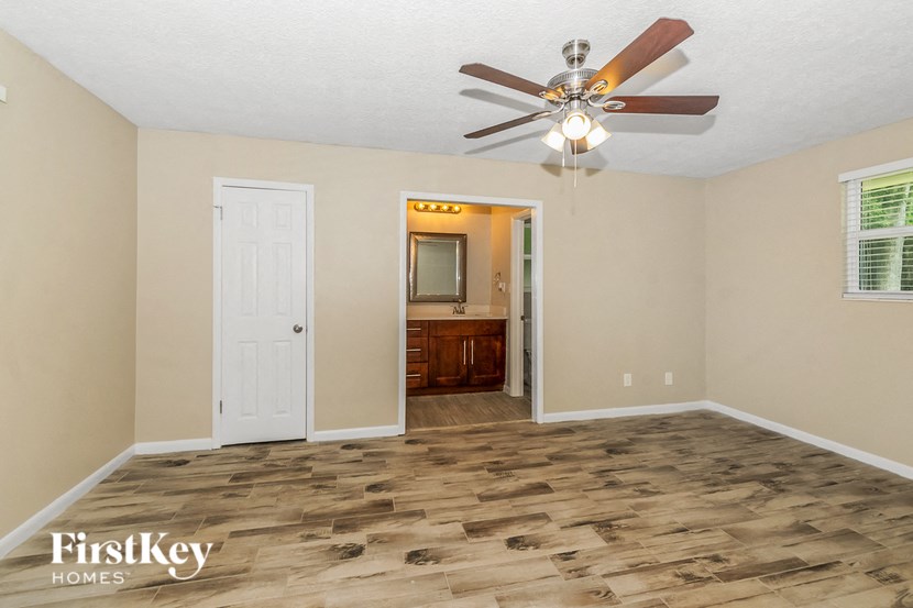 the living room with wood flooring and a ceiling fan