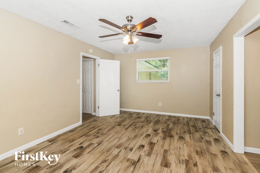 the living room has a ceiling fan and hardwood floors