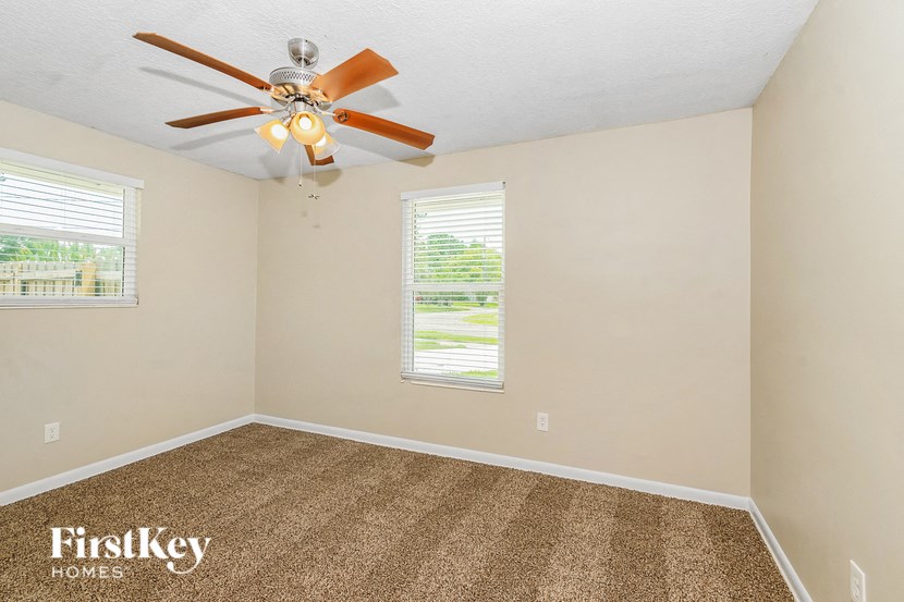 the living room has a ceiling fan and a carpet