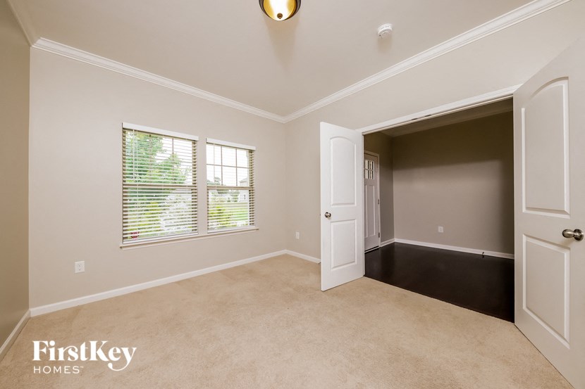 an empty living room with a door and a window