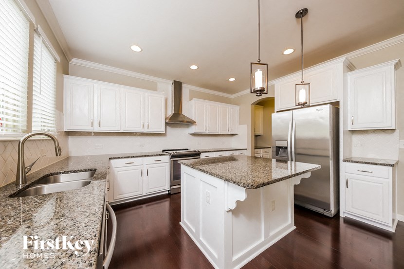 a kitchen with white cabinets and granite counter tops