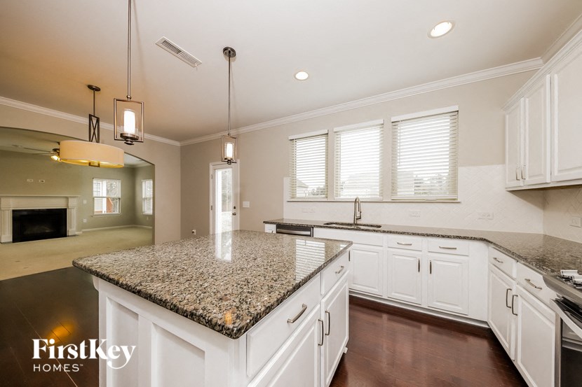 a large kitchen with white cabinets and granite counter tops