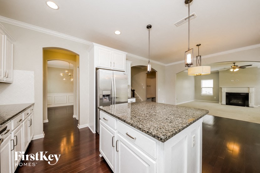 an open kitchen with white cabinets and granite counter tops