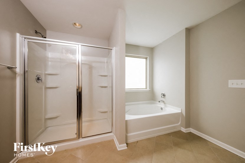 a bathroom with a tub and a shower and a sink
