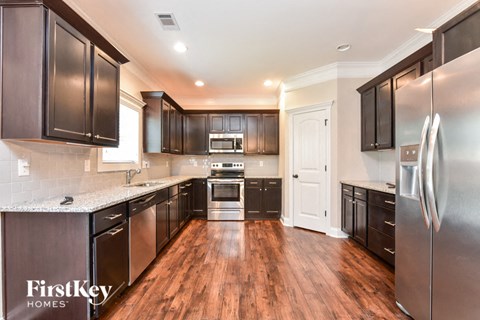 a kitchen with black cabinets and stainless steel appliances