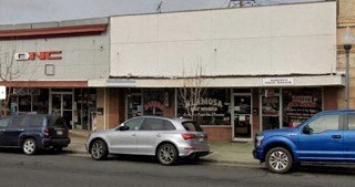 Three cars are parked in front of a building with a sign that says "CMC.".