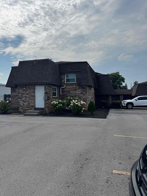 A house with a white car parked in front.