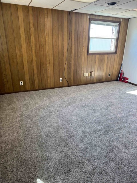 A room with a carpeted floor and a window.
