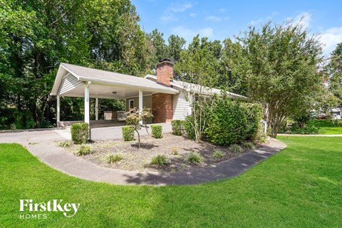 A house with a white porch and a green lawn in front.