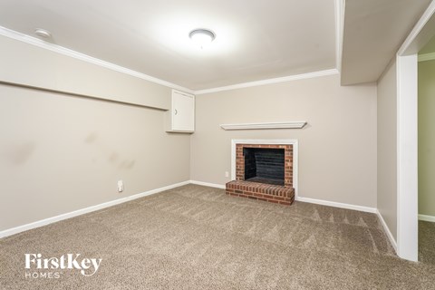 A room with a fireplace and a carpeted floor.