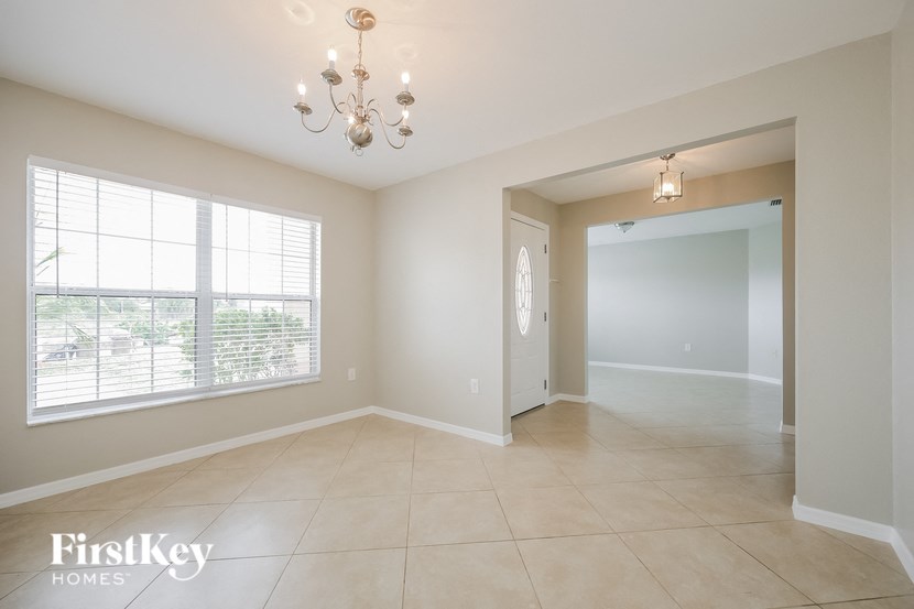an empty living room and dining room with a large window
